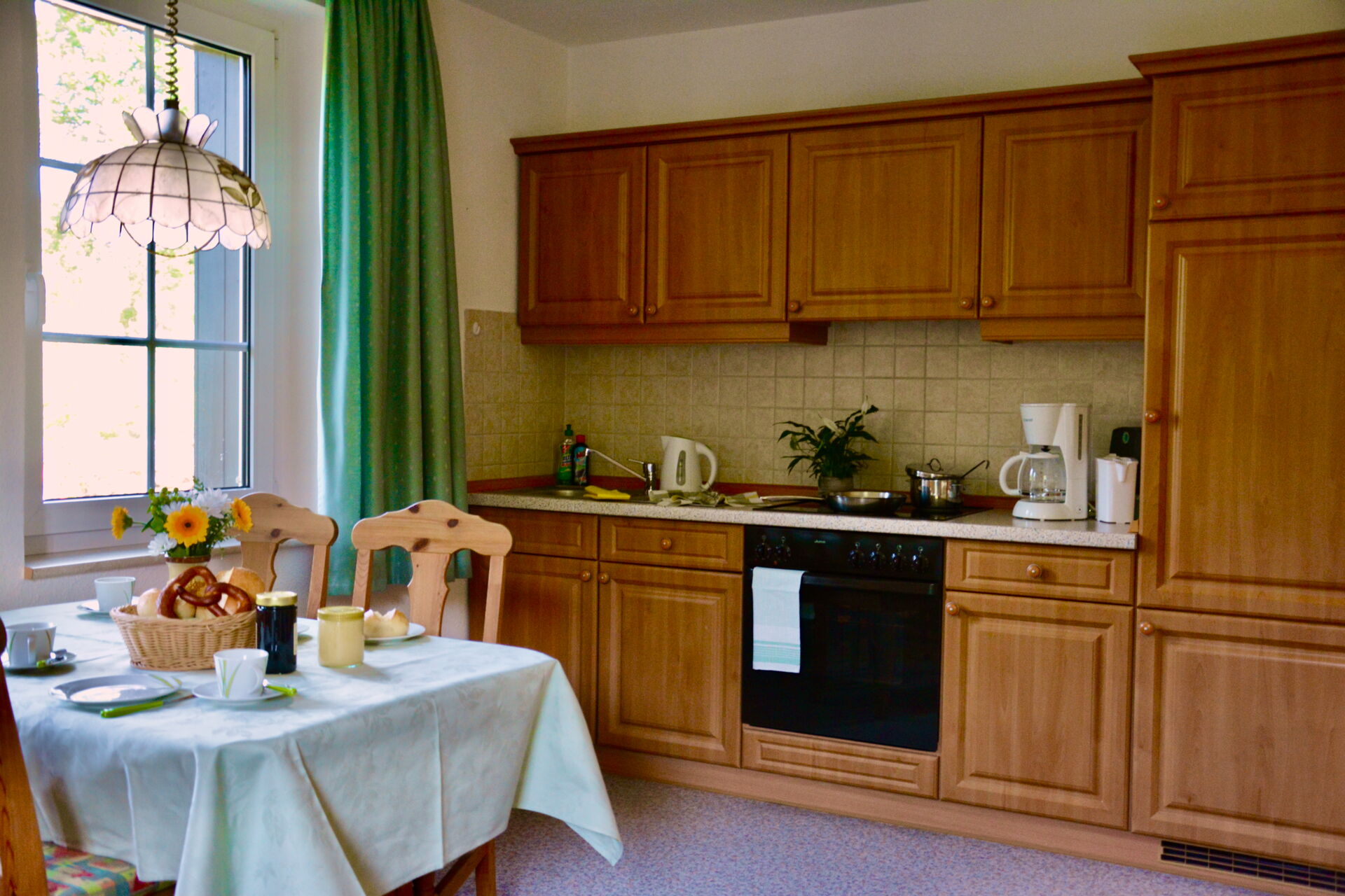 wohnliche Küche Eine Küche mit Holzeinbauten und kleinem Esstisch.